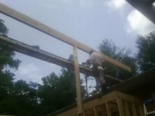 Carpenter setting a ridge beam over a new addition frame — Ice Dam Removal by Roofing Brothers in Alamance