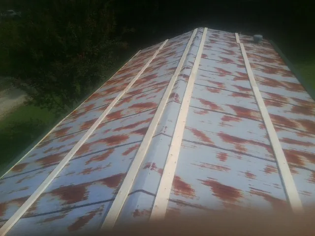 Rusted metal roof panels with new wood purlins before replacement — Storm Damage Roof Repair in Alamance by Roofing Brothers