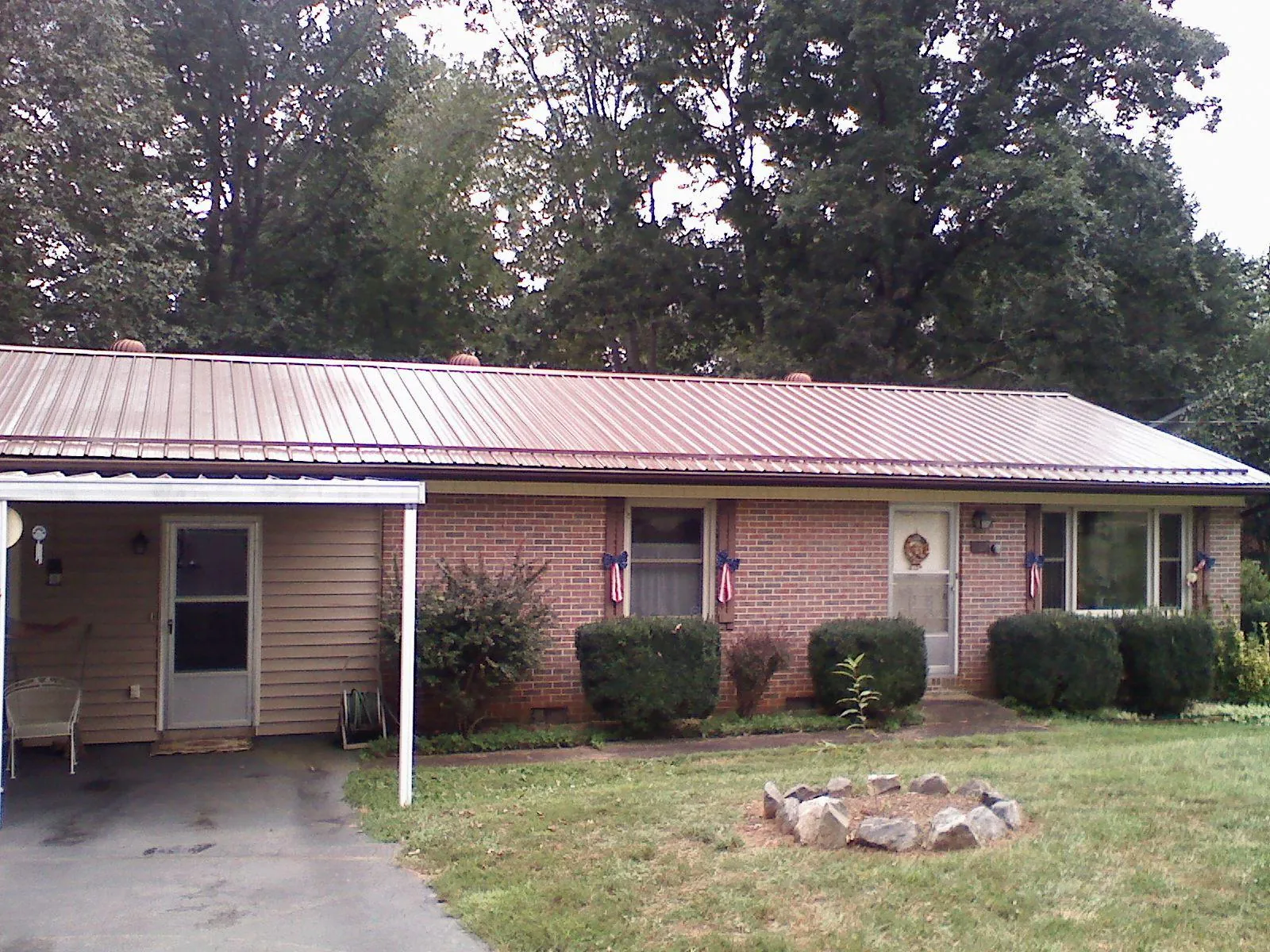 Bronze metal roof and carport on a brick ranch home — Roof Repair work by our crew in Alamance